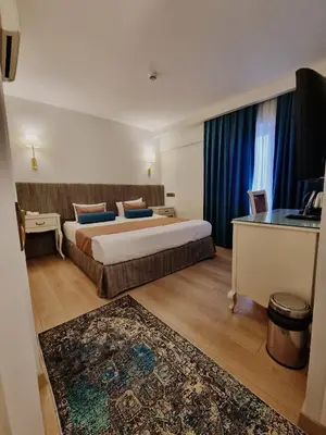 a hotel room with a large bed and a desk at Taximtown Hotel in Istanbul