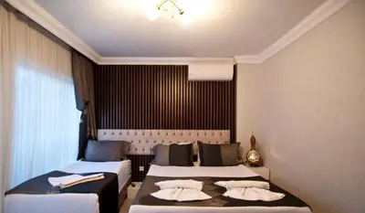 a hotel room with two beds and a window at Hotel Broken Column in Istanbul