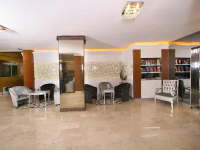 a lobby with chairs and tables and a mirror at Maya Hotel in Istanbul