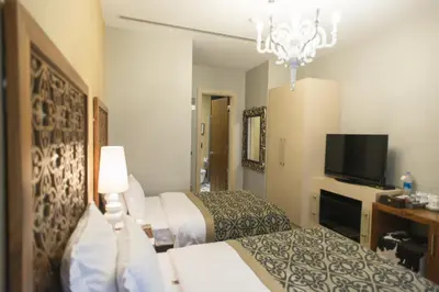 a hotel room with two beds and a flat screen tv at Taksim Prelude Hotel in Istanbul
