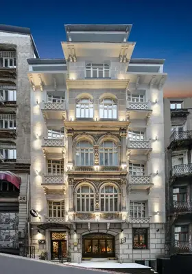 a tall white building with lights on it at The Story Hotel Pera in Istanbul