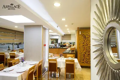 a restaurant with white tables and wooden chairs at Aspalace Hotel The Istanbul Old City in Istanbul