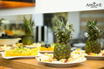 a table topped with plates of food with pineapples and fruit at Aspalace Hotel The Istanbul Old City in Istanbul