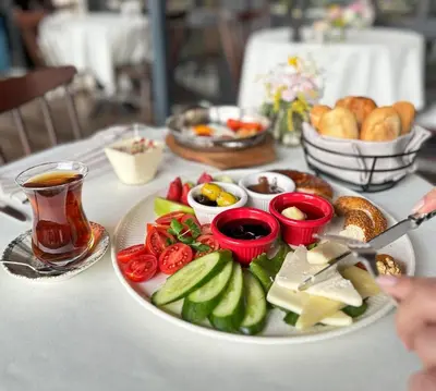 a table with a plate of food and a cup of tea at Meroddi Pera Flats in Istanbul