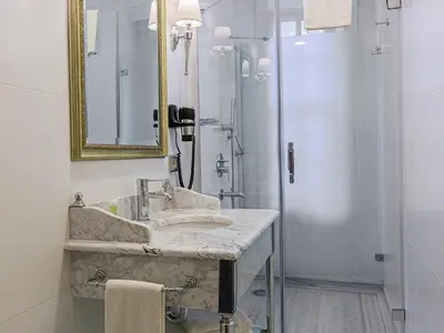 a bathroom with a sink and a shower with a mirror at Meroddi Pera Flats in Istanbul