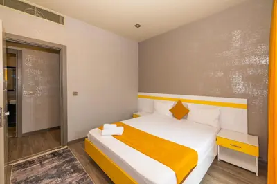 a bedroom with a bed with a yellow and white bedspread at Agora Suites in Esenyurt