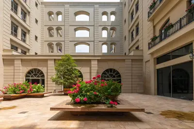 a large building with flowers in a courtyard at Agora Suites in Esenyurt