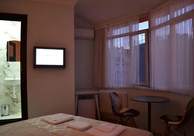 a room with a table and chairs and a television at Yeni Hotel in Istanbul