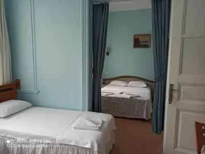 two beds in a room with a mirror at Yeni Hotel in Istanbul