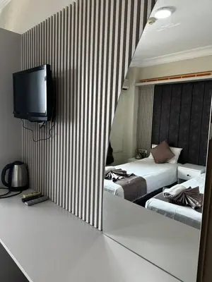 a hotel room with two beds and a tv on the wall at Divas Silver in Istanbul