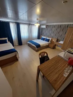 a large room with two beds and a table at Aslan Home Apart in Istanbul