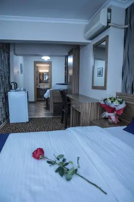 a hotel room with a bed with a rose on it at Aslan Home Apart in Istanbul