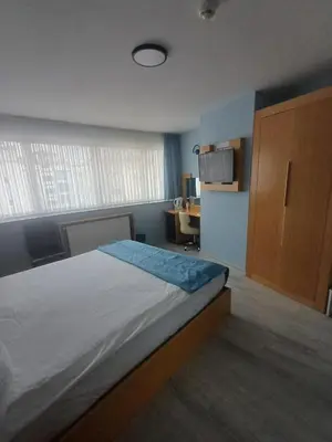 a bedroom with a bed and a cabinet and a desk at Golden Palas Hotel in Cerkezkoy