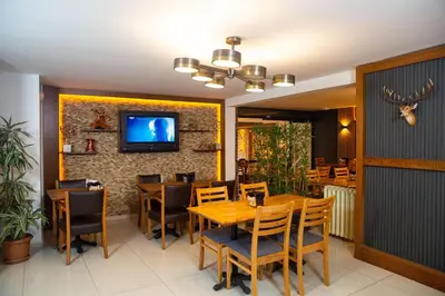 a dining room with a table and chairs and a tv at Emirtimes Hotel Kadıköy in Istanbul