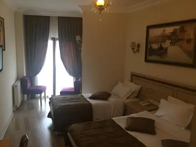 a hotel room with two beds and a window at Sultan Palace Hotel in Istanbul