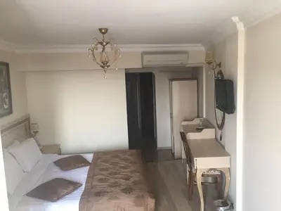 a bedroom with a bed and a desk and a television at Sultan Palace Hotel in Istanbul