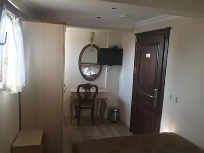 a bedroom with a bed and a mirror and a chair at Sultan Palace Hotel in Istanbul