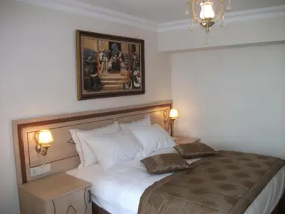 a bedroom with a large white bed with two pillows at Sultan Palace Hotel in Istanbul