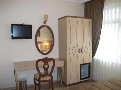 a room with a desk and a mirror and a chair at Sultan Palace Hotel in Istanbul