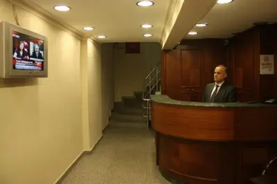 a man is standing at a counter in a room at Hotel Ay in Istanbul