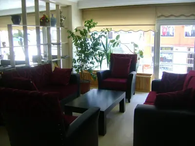 a waiting room with red chairs and a coffee table at Hotel Ay in Istanbul