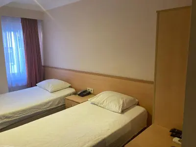 a hotel room with two beds and a window at Hotel Ay in Istanbul