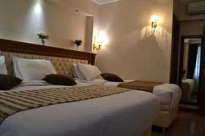 a hotel room with two beds and a mirror at Seven Days Hotel - İstanbul in Istanbul