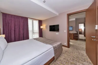 a hotel room with a bed and a television at Land Park Hotel in Istanbul