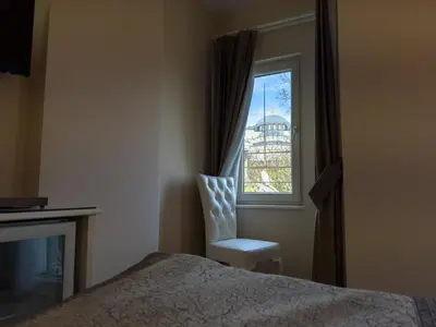 a bedroom with a bed and a window with a chair at Sarnic Premier Hotel in Istanbul