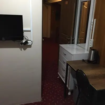 a room with a dresser and a desk with a computer at Paris Hotel in Istanbul