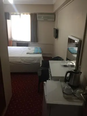 a small hotel room with a bed and a window at Paris Hotel in Istanbul