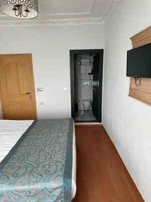 a room with a bed and a bathroom with a toilet at Blue Tuana Hotel Old City in Istanbul