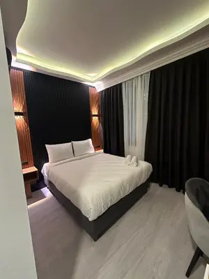 a bedroom with a large bed with white sheets at Rays Hotel - Bakirkoy Istanbul City Center in Istanbul