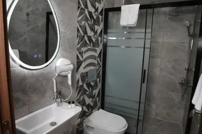 a bathroom with a toilet and a sink and a mirror at Rays Hotel - Bakirkoy Istanbul City Center in Istanbul