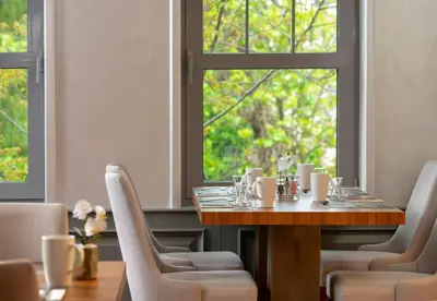 a dining room with a table and chairs and a window at Millennium Istanbul Golden Horn in Istanbul