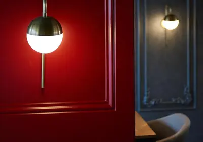 a room with a red wall with a lamp and a table at Dundar Hotel & Spa in Istanbul