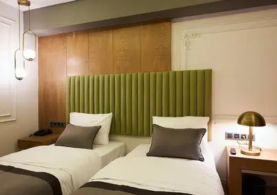 a hotel room with two beds and a green headboard at Dundar Hotel & Spa in Istanbul