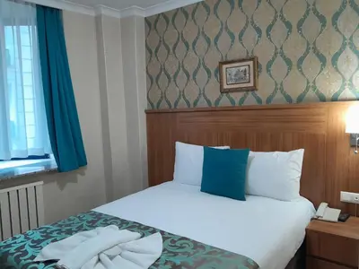 a bedroom with a bed with blue and white pillows at Grand Dilara Hotel in Istanbul