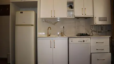 a kitchen with white cabinets and a refrigerator at Blue Eye Suites in Istanbul