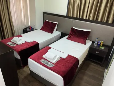 two beds in a hotel room with red sheets at Pandora Hotel in Istanbul