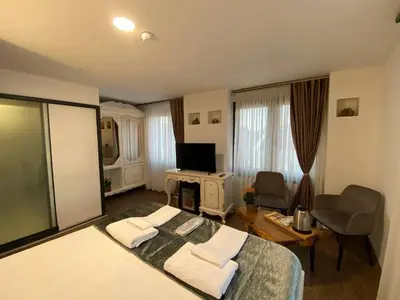 a bedroom with a large bed and a living room at Pandora Hotel in Istanbul