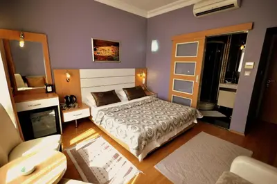 a bedroom with a bed and a couch in a room at Khalkedon Hotel Istanbul in Istanbul