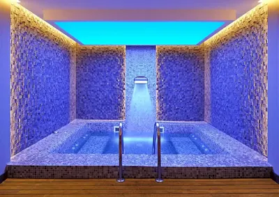 a bathroom with a large tub with blue tiles at Fraser Place Anthill Istanbul in Istanbul