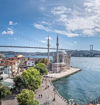 a mosque on the water with a bridge in the background at The Stay Bosphorus in Istanbul