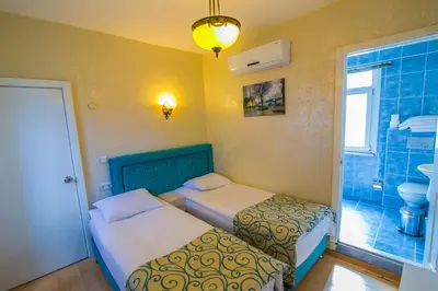 two beds in a small room with a bathroom at Ancient Town Hotel in Istanbul