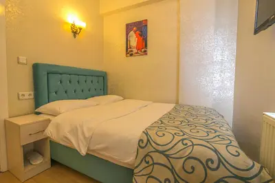 a small bedroom with a bed with a blue headboard at Ancient Town Hotel in Istanbul