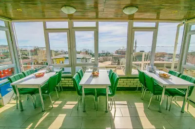 a restaurant with two tables and green chairs and windows at Ancient Town Hotel in Istanbul