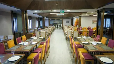 a dining room with wooden tables and chairs at Kervansaray Bursa City Hotel in Bursa