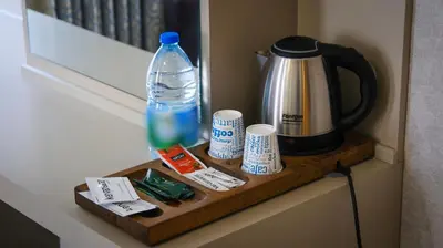 a table with a coffee maker and a bottle of water at Kervansaray Bursa City Hotel in Bursa