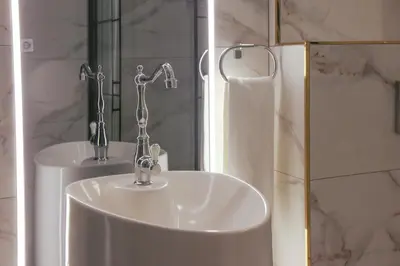a bathroom sink with two faucets in front of a mirror at Harbiye Residence in Istanbul